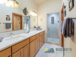 The full primary bathroom has double sinks, a walk-in shower with dual shower heads, and a private toilet.